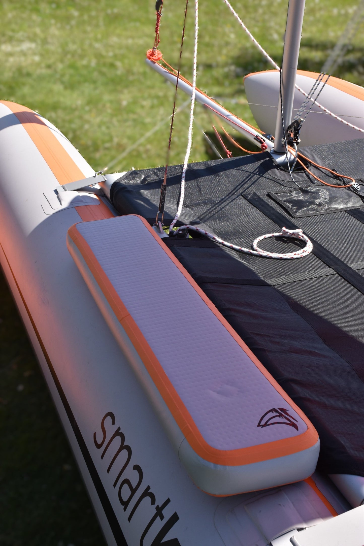 smartkat® aufblasbarer Katamaran in Grau mit orangefarbenen Akzenten, leicht und wendig für Segelspaß.